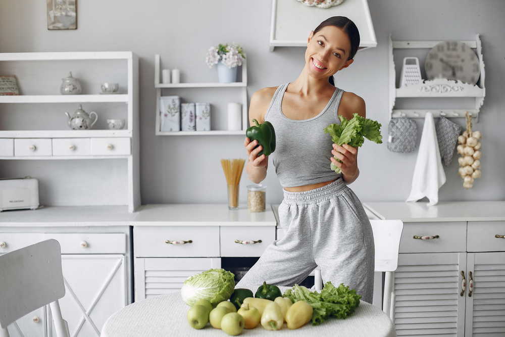 beautiful sporty woman kitchen with vegetables