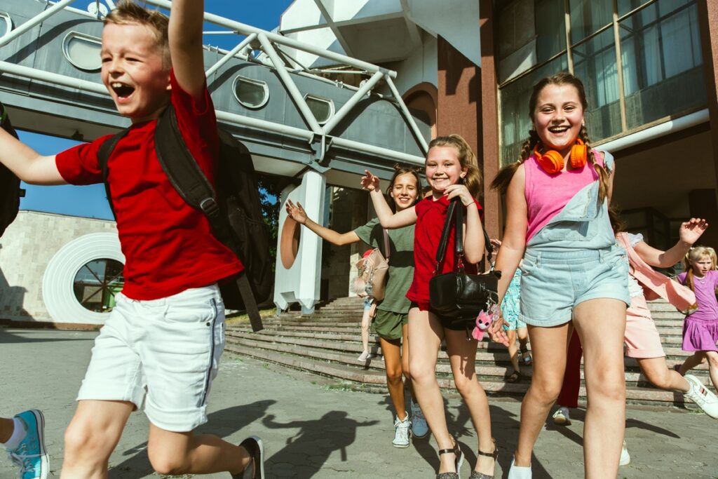 happy kids playing city s street sunny summer s day front modern building group happy childrens teenagers having fun together concept friendship childhood summer holidays