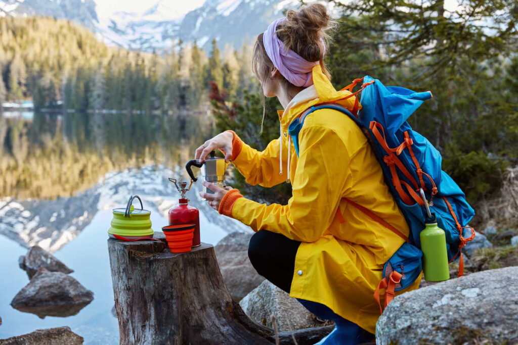 Рекомендации по экскурсиям и активному отдыху 3 outdoor view young woman uses tourist equipment making coffee has portable gas stove stump