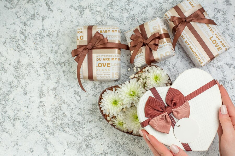 Как выбрать идеальный подарок на любой случай: советы и идеи 3 close up view hand opening heart shaped box with beautiful flowers gifts ice background 140725 160464