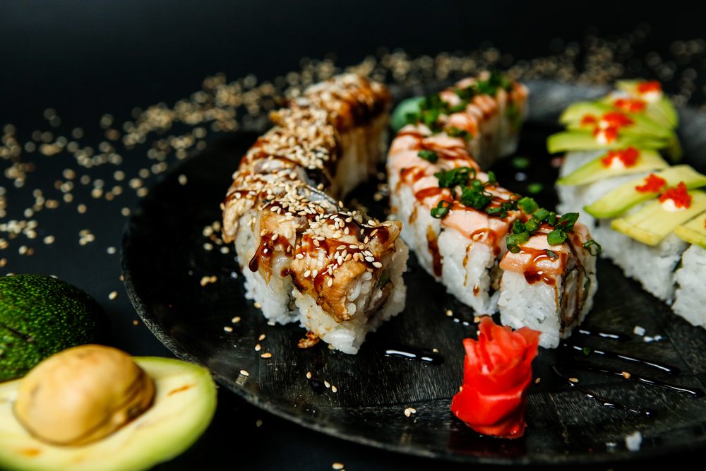 lots various types sushi rolls topped with sesame seeds close up view