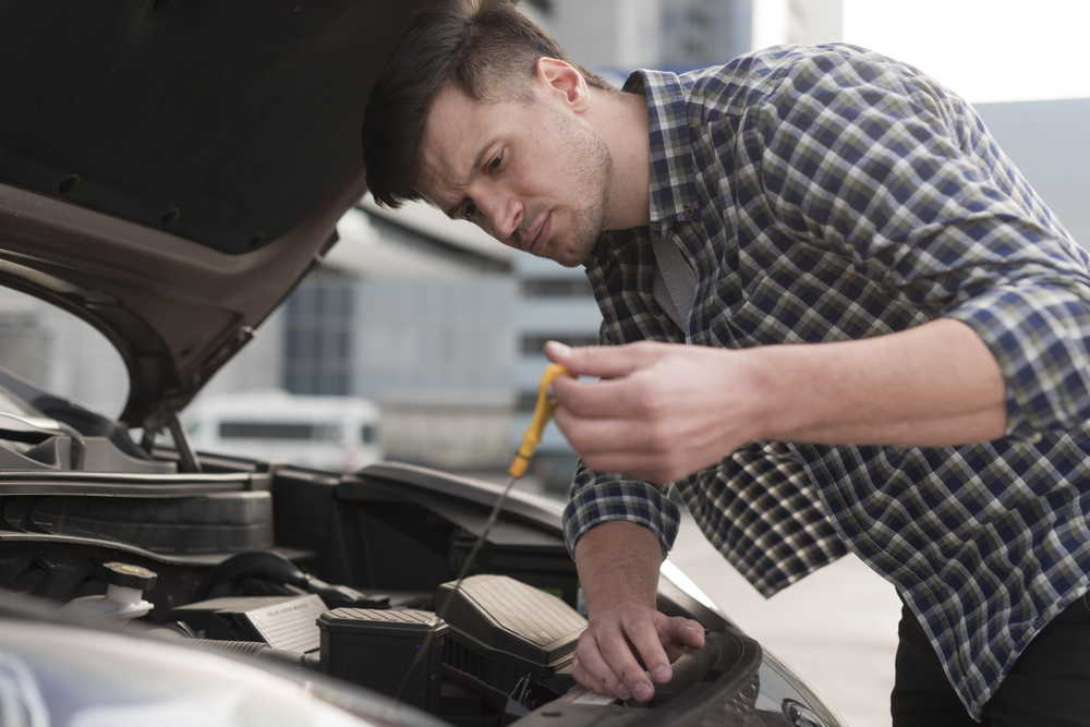 low angle man fixing car