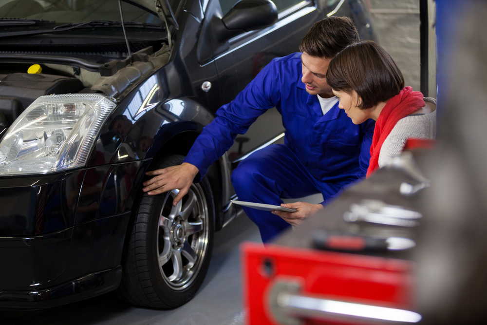 mechanic showing customer problem with car