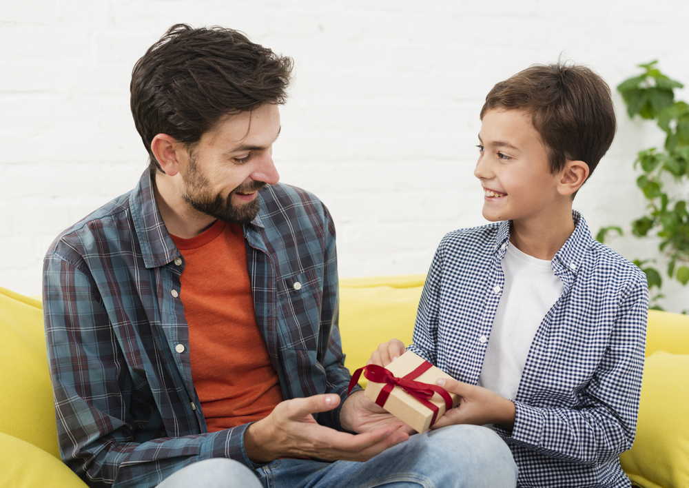 smiling son offers gift his father
