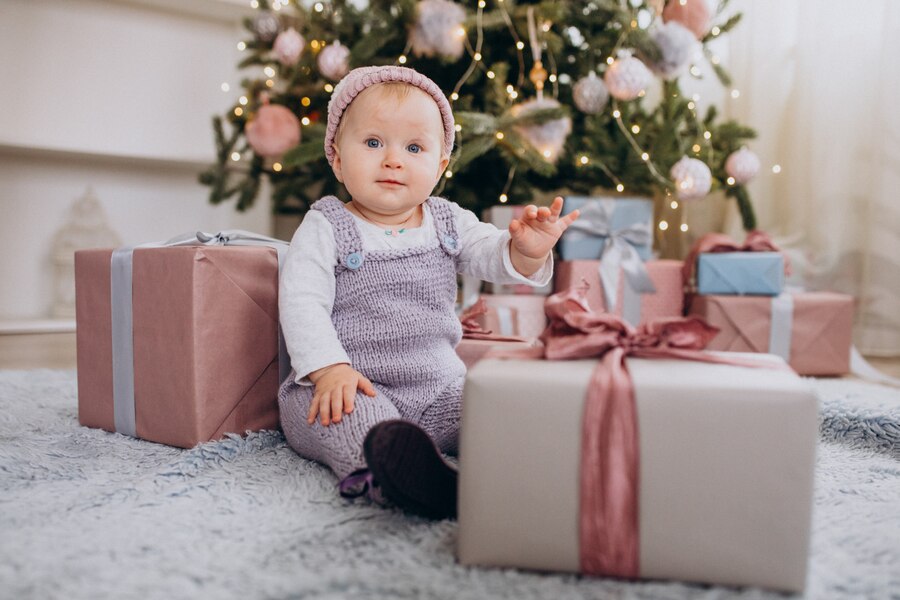cute little baby girl sitting by christmas presents 1303 19154