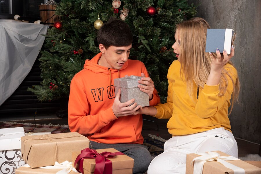 young couple sitting floor with presents near christmas tree 114579 90147