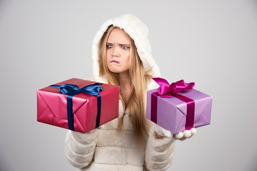 Что не следует дарить на Новый год: Блэклист подарков 2 blonde woman angrily looking gift boxes 114579 80401
