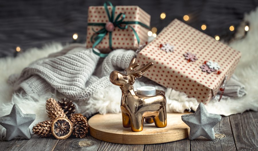 Когда Рождество в 2025 году: история и традиции праздника 2 christmas festive wall with toy deer with gift box christmas tree blurred wall with golden lights wooden deck table