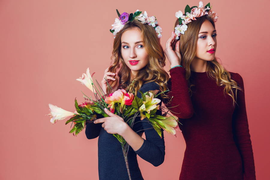 close up studio portrait two young pretty blonde women spring flowers wrath amazing wavy long hairstyle bright make up looking camera
